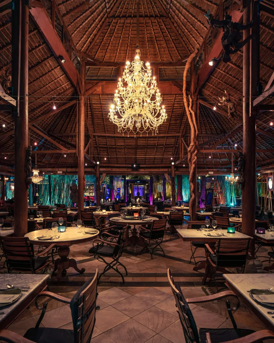 Bambuddha restaurant in Ibiza features a stunning chandelier and bamboo-themed decor with ambient lighting.