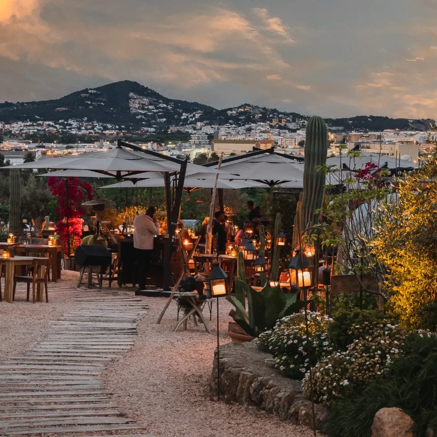 Casa Maca Ibiza restaurant at sunset, with lanterns and mountain view