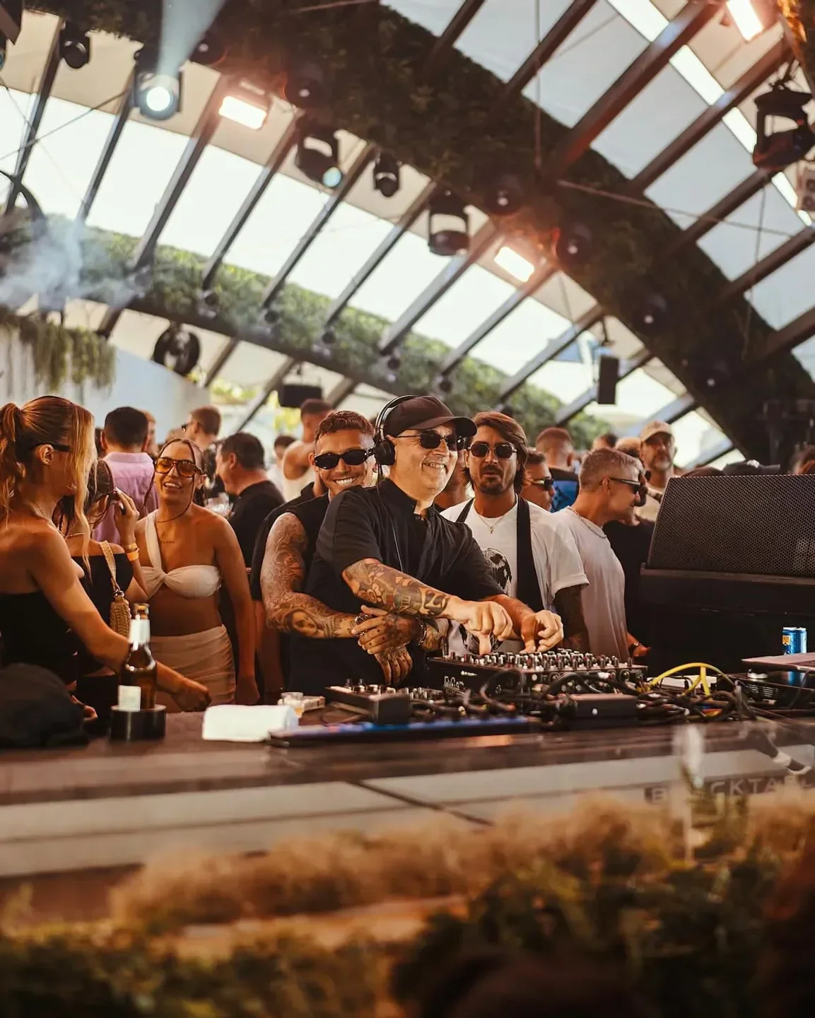DJ playing at Destino Ibiza beach club with a crowd enjoying the summer party.