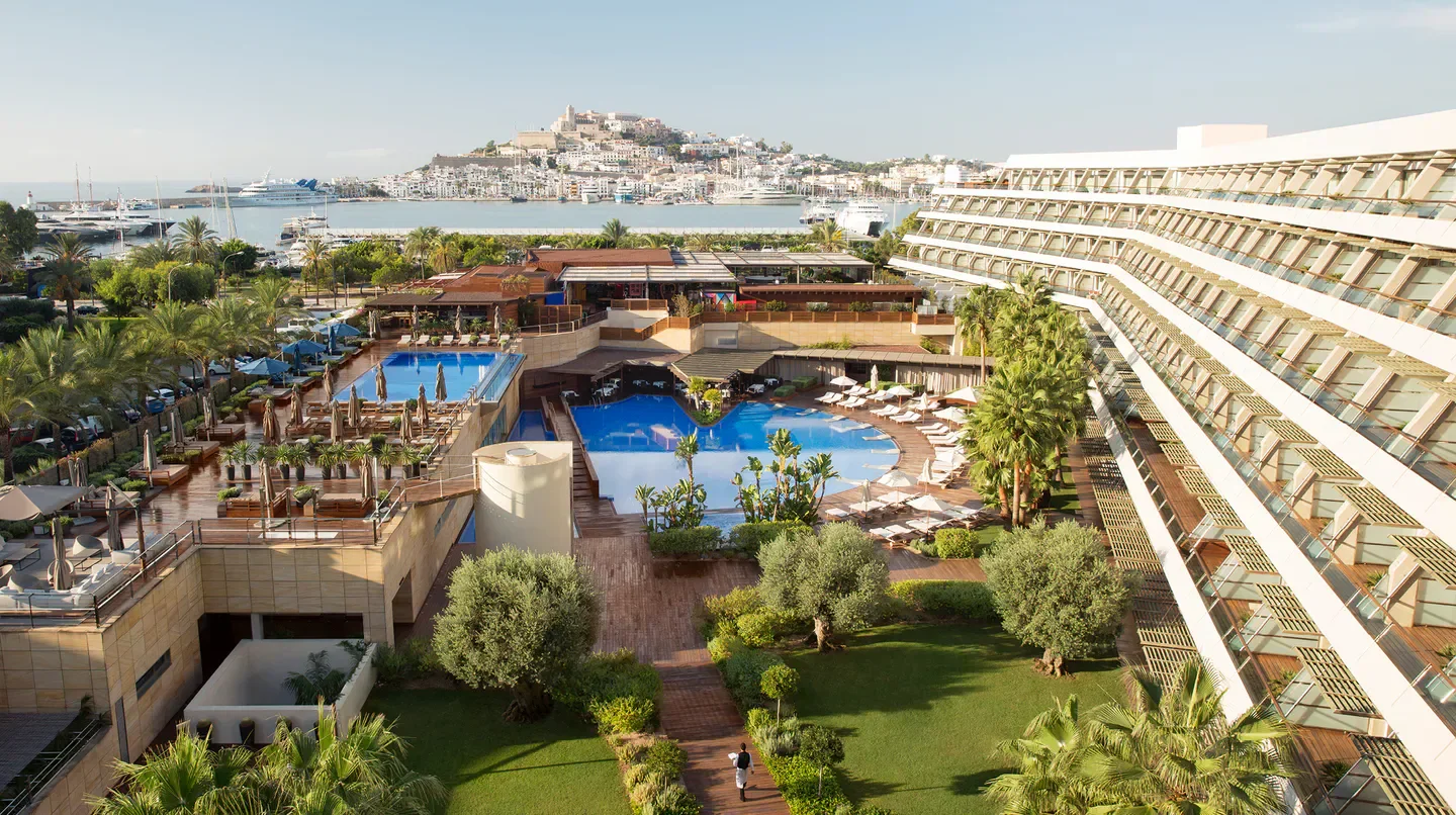 Aerial view of Ibiza Gran Hotel with pool and Ibiza town in the background.