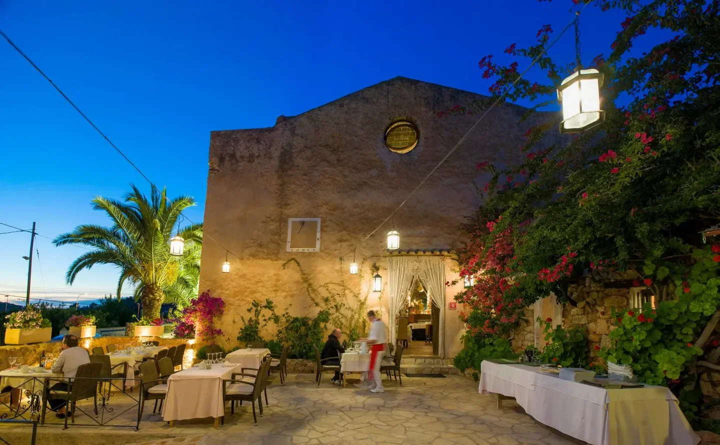 Outdoor dining at Sa Capella restaurant in Ibiza, featuring a historic building.