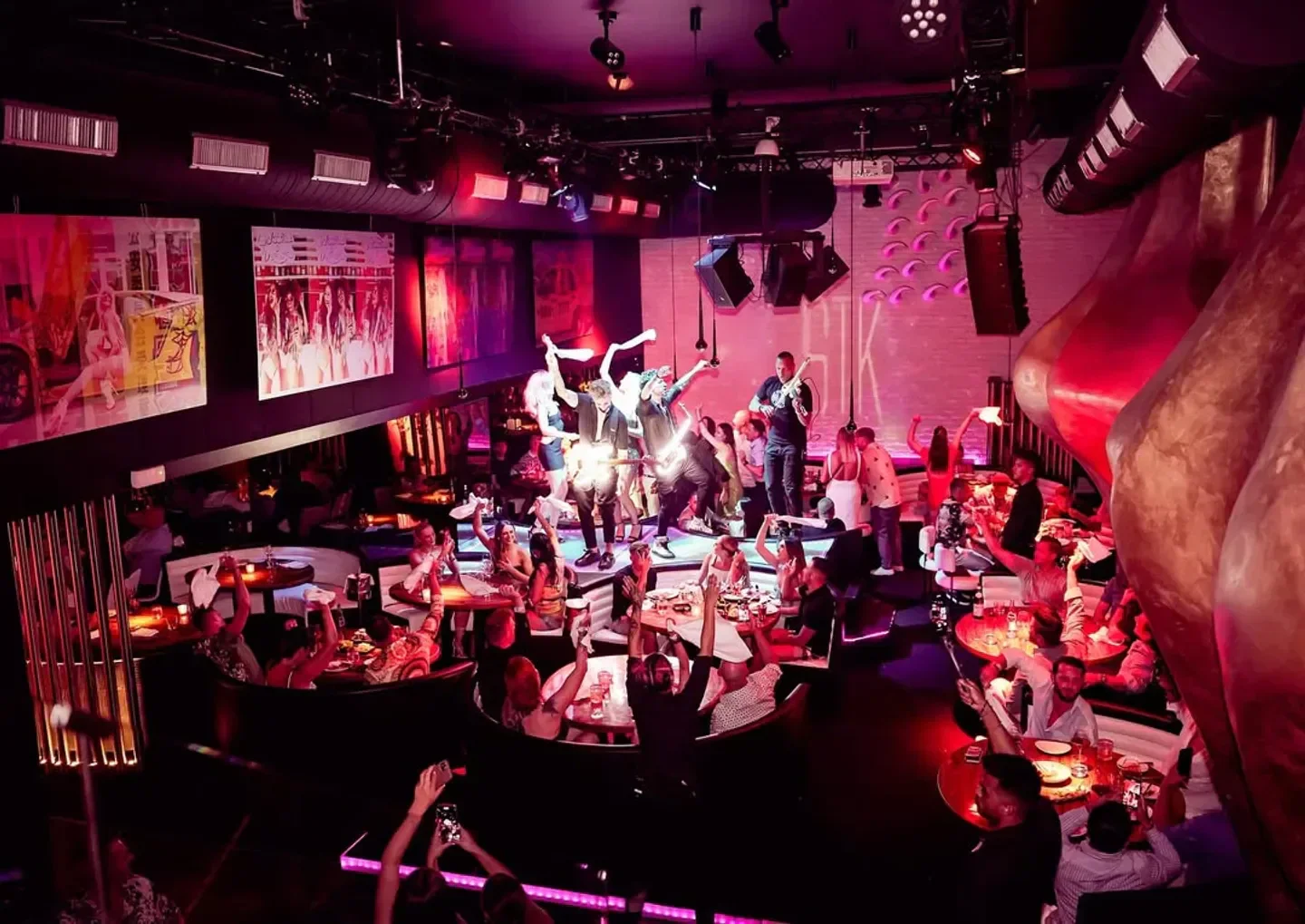 STK Ibiza nightclub interior with performers on stage and lively crowd enjoying the night