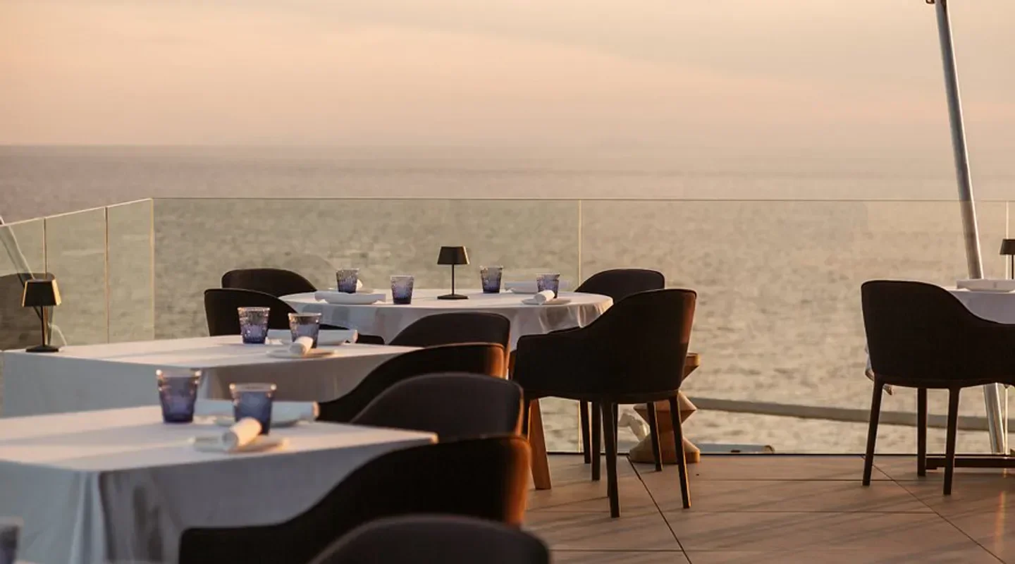 Tables set at The View restaurant in Ibiza, overlooking the sea at sunset.