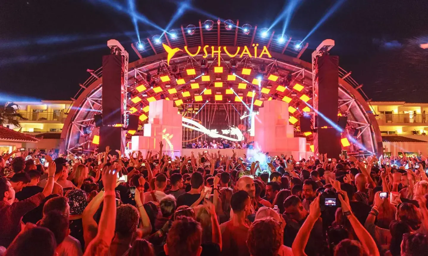 Energetic crowd at Ushuaïa Ibiza nightclub, under bright lights and stage.